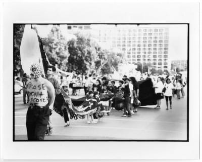 Guillermo Gómez-Peña, Please Don’t Discover Me/Passa Calle, 1992, black-and-white photograph, opening procession, National Association of Artists Organizations Conference, Austin, Texas, 1992 (artwork © Guillermo Gómez-Peña; photograph provided by the Portal to Texas History, University of North Texas, http://texashistory.unt.edu/ark:/67531/metapth304065/)