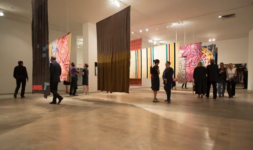 Installation view, Unsuspected Possibilities: Leonardo Drew, Sarah Oppenheimer, and Marie Watt, 2015, SITE Santa Fe, July 2015–January 2016 (artwork © Marie Watt; photograph by Kate Russell, provided by SITE Santa Fe)  The gallery, with installations by the three artists, was configured to evoke the footprint of a longhouse, a form of architecture built by the Haudenosaunee (Iroquois Nation). “I made my piece in collaboration with the Santa Fe Indian School, Santa Fe University of Art and Design, Tierra Encantada High School, Institute of American Indian Arts, and other members of the Santa Fe community. I was initially inspired by research into the Mohawk ironworkers who built many of Manhattan’s skyscrapers, an abstract correlation between the structure of the longhouse and the structure of the skyscraper, and the dense living communities and neighborliness that result from both.”