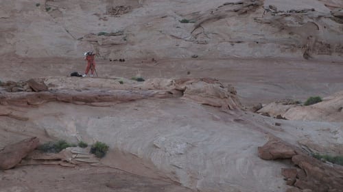 The Ob-surveyor, performed by Katherine Hubbard, seen here setting up a camera in the desert landscape. A.K. Burns, video still from A Smeary Spot, 2015, four-channel video installation, HD color, six-channel sound, TRT 53:13 (artwork © A.K. Burns, image provided by the artist, Callicoon Fine Arts, NY, and Michel Rein Gallery, Paris/Brussels)