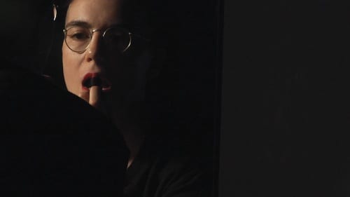 Simon (Grace) Dunham performs as a Free Radical and applies lipstick in the mirror. A.K. Burns, video still from A Smeary Spot, 2015, four-channel video installation, HD color, six-channel sound, TRT 53:13 (artwork © A.K. Burns; image provided by the artist, Callicoon Fine Arts, NY, and Michel Rein Gallery, Paris/Brussels)