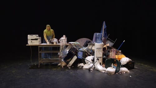 Nayland Blake is Aunt Be/e who performs as re/productive labor. In this scene, she operates a Xerox machine, making copies of objects that have been scavenged from the junk pile that her work station is built from. A.K. Burns, video still from A Smeary Spot, 2015, four-channel video installation, HD color, six-channel sound, TRT 53:13 (artwork © A.K. Burns; image provided by the artist, Callicoon Fine Arts, NY, and Michel Rein Gallery, Paris/Brussels)