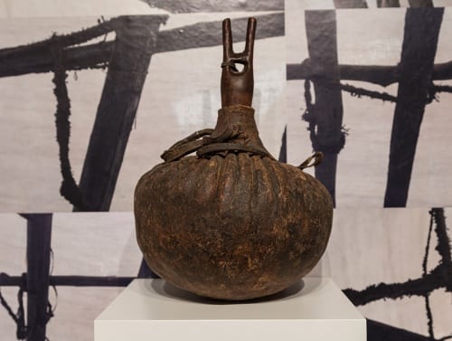 Unidentified artist, Turkana (Kenya), vessel for milk, ca. 1970s camel stomach, basketry, wood, and leather, installation view in 