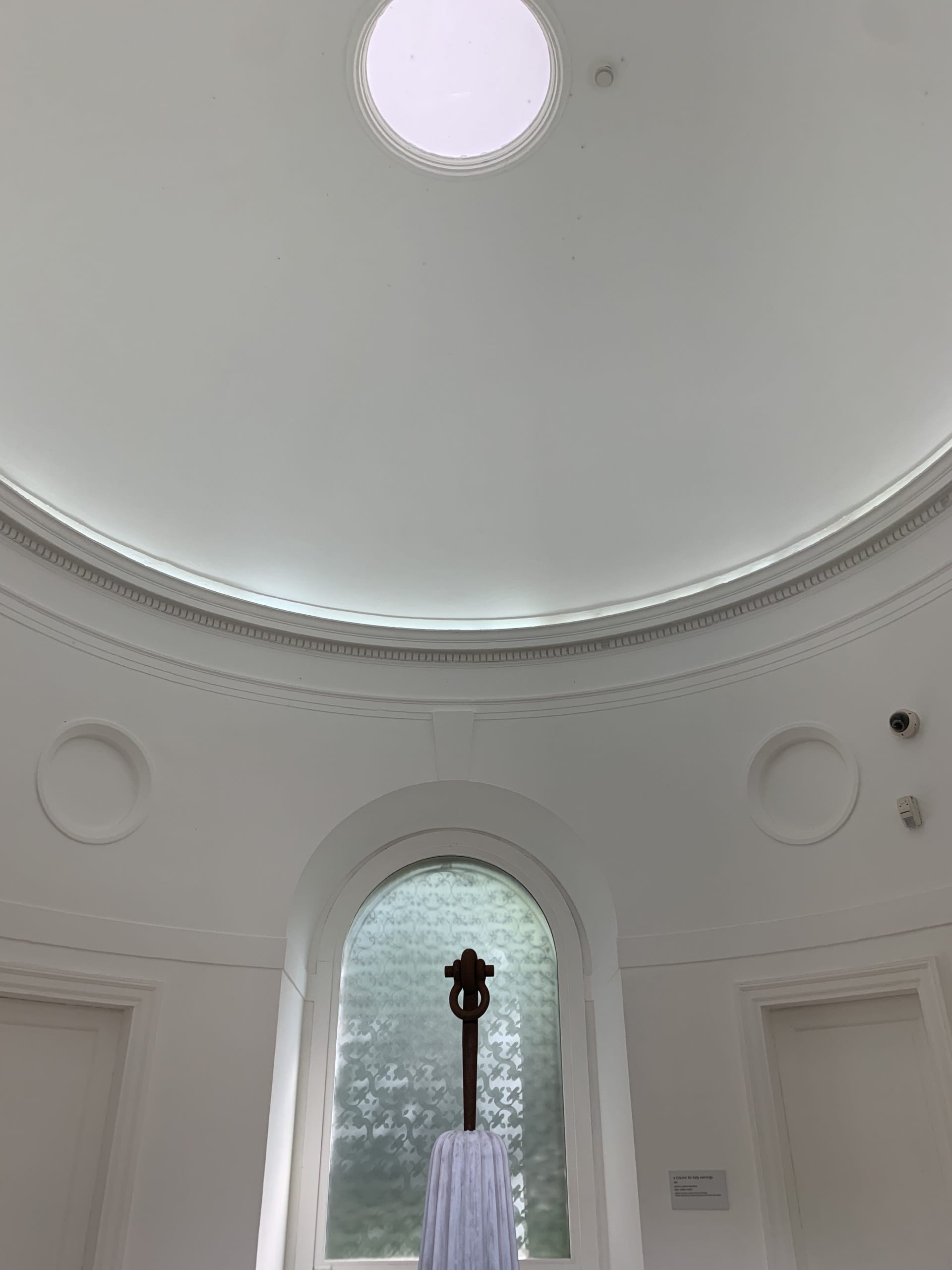 light-filled Neo-Classical rotunda with an oculus. A tapered column from which a single iron shackle rises