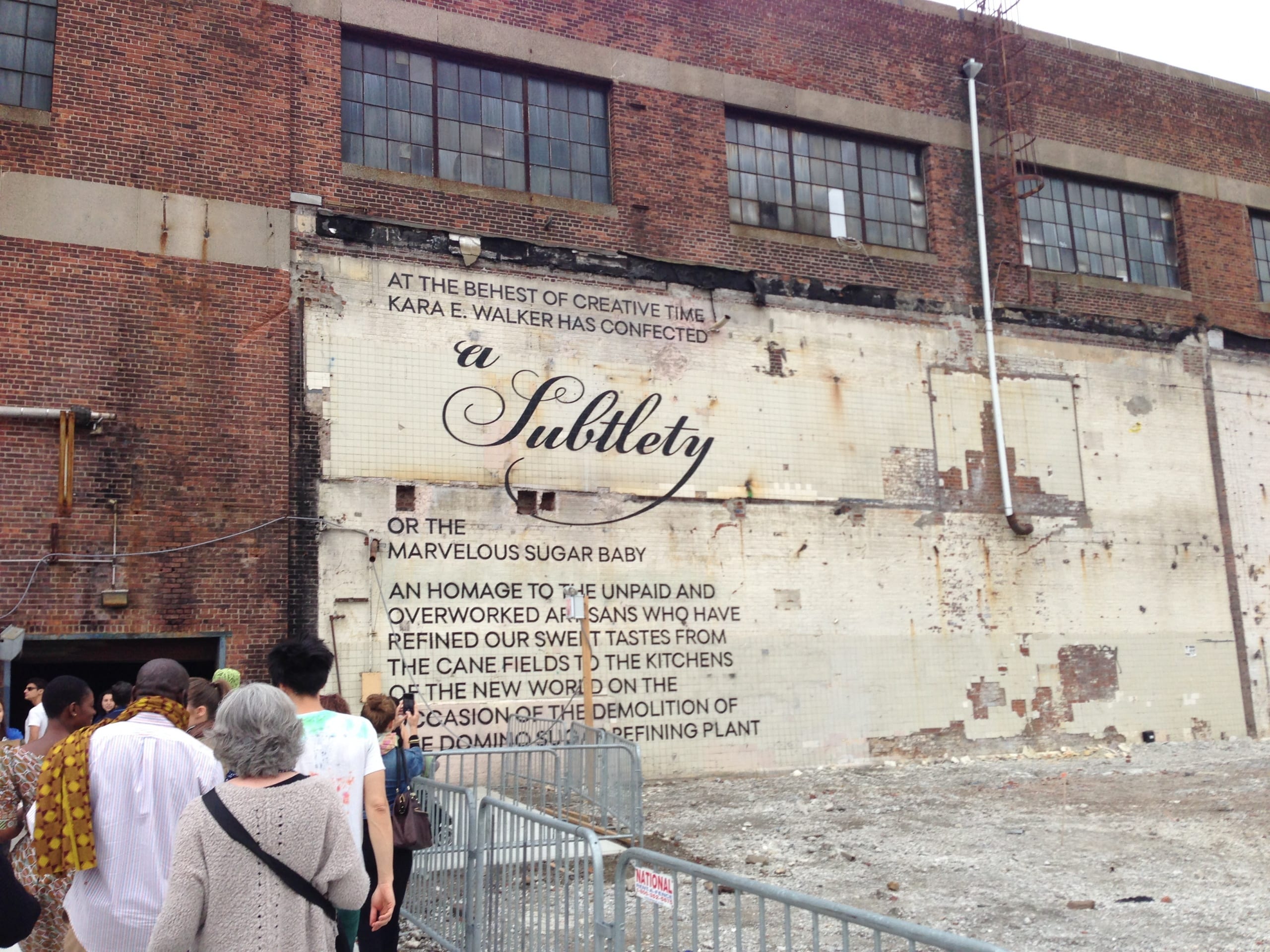 "A Subtlety" printed onto red brick walls of a factory