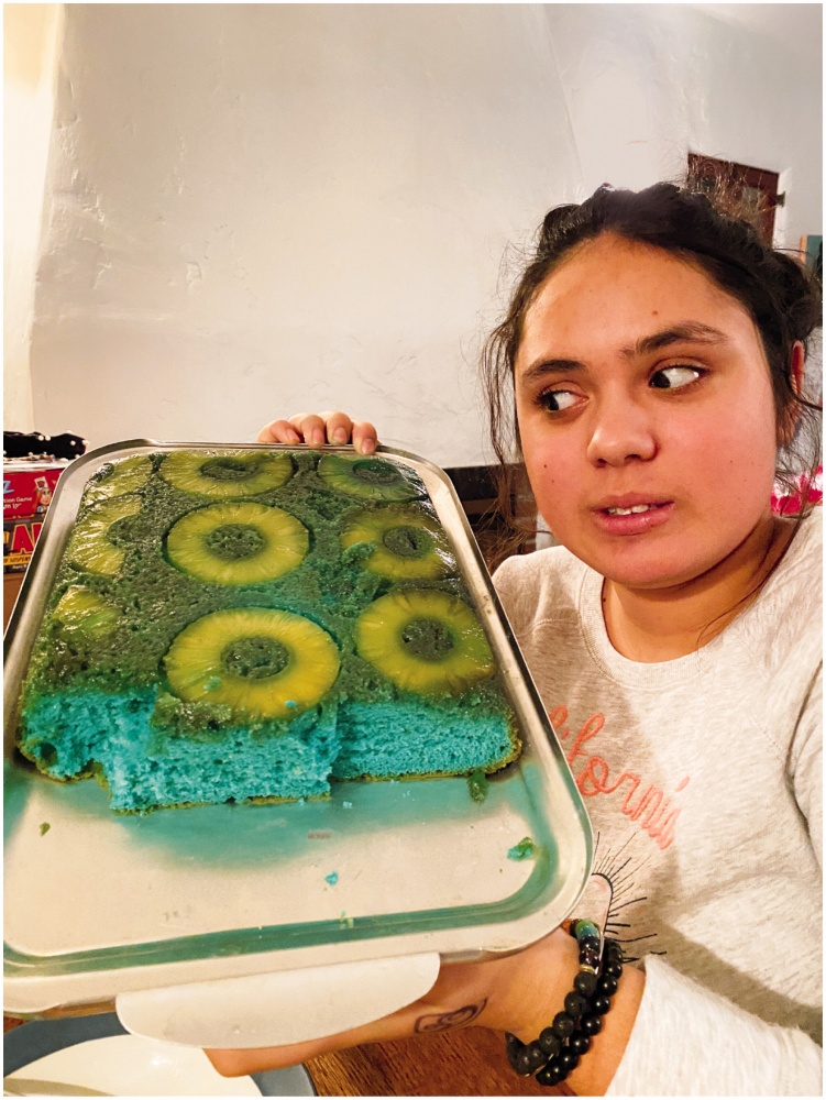 a photograph of a person showing off a blue cake