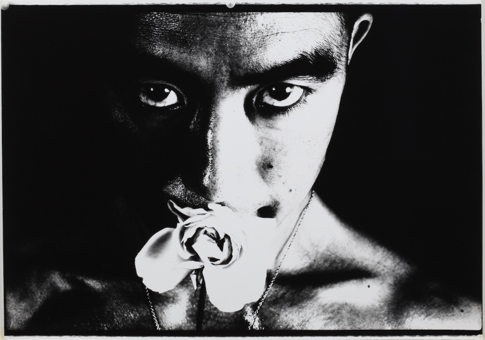 Black and white image of man with rose in his mouth