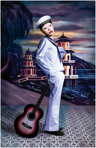 A figure in a sailor's suit, white mask, red lips, black shoes on a patterned floor leaning on a guitar. In the background, painted scenery of a pagoda.