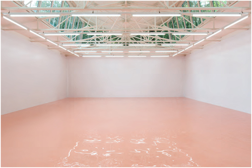 A large pool of pink colored liquid. Florescent lights under the cieling. Sunlight comes in through the exposed parts of the roof. Above, green trees.