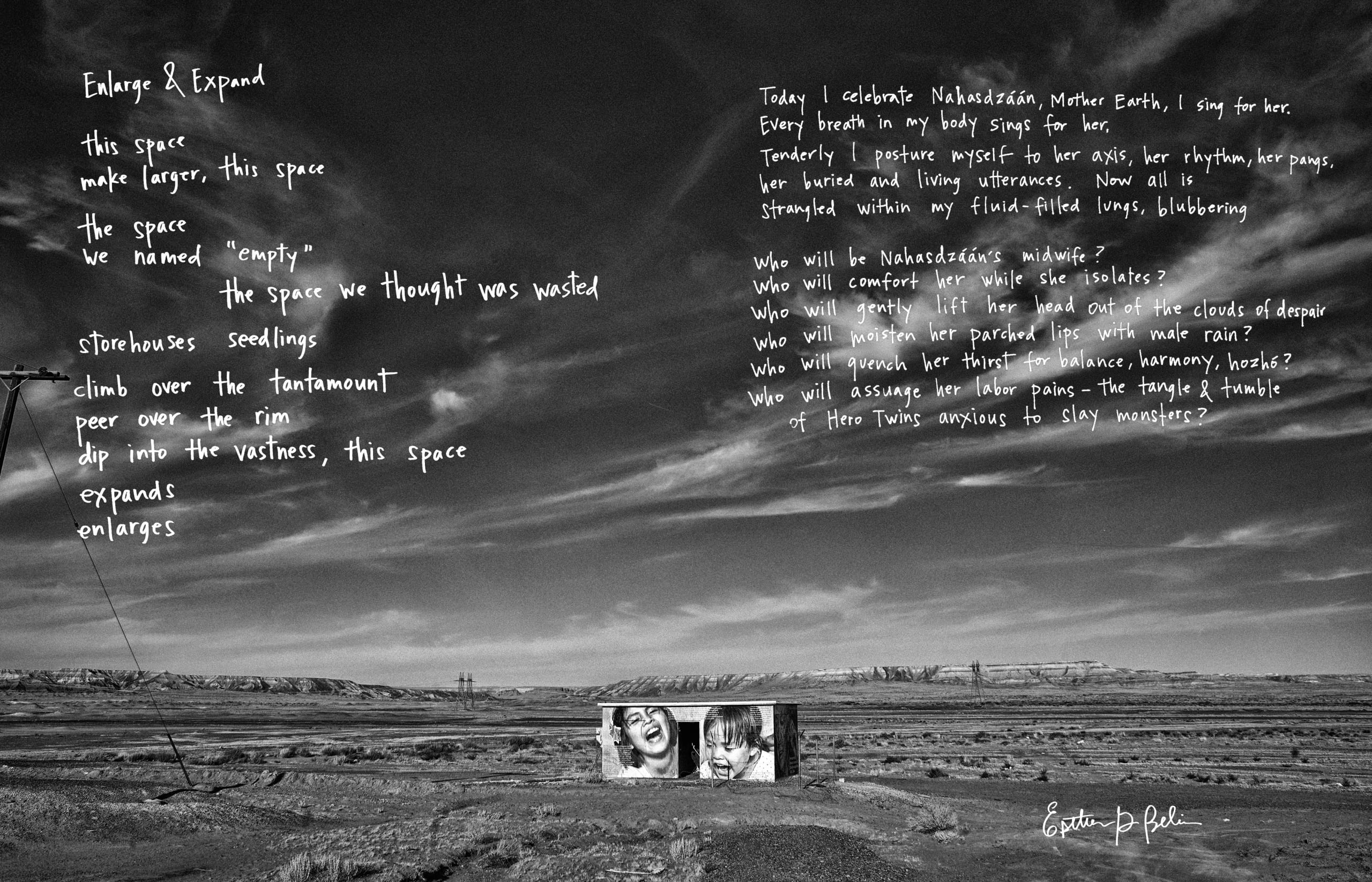 Black and white photo of sky occupying two-thirds of frame; a small, flat-roofed, rectangular building at center front is wrapped in an enlarged black and white photographic mural of two young children, laughing; a handwritten poem is printed in white text against the sky