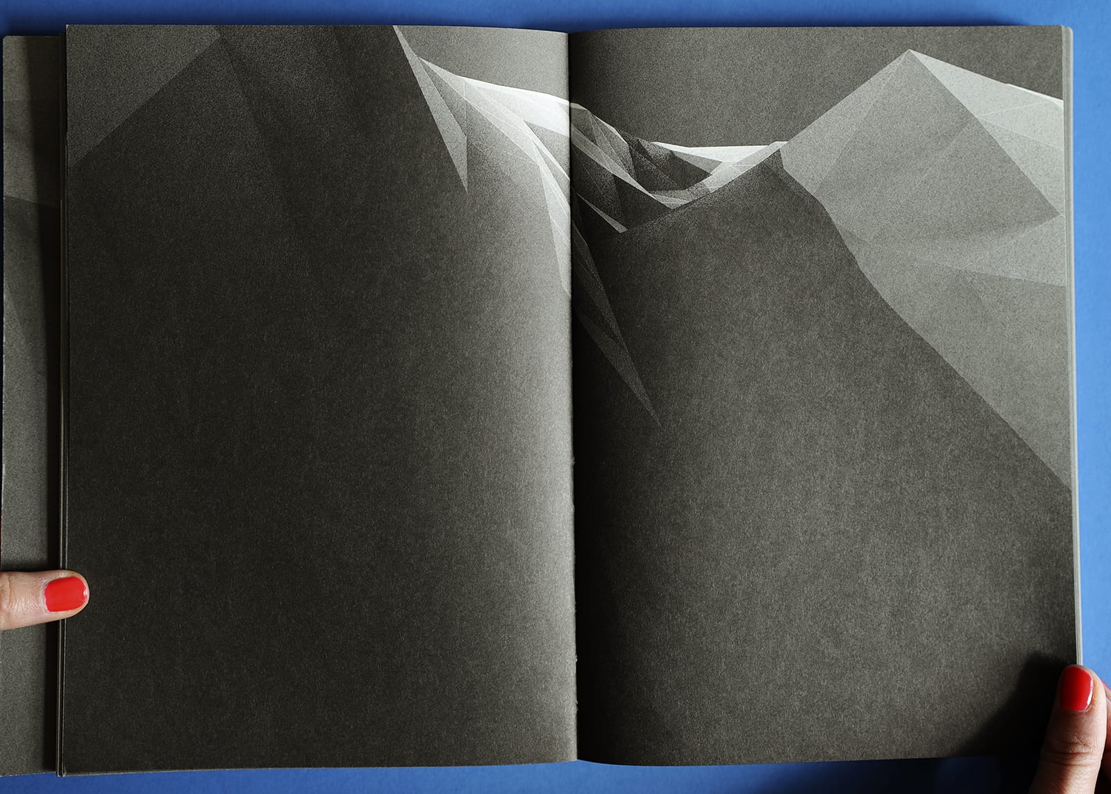 Open-book spread of Imaginary Explosions. Black-and-white graphic of mountain topography.